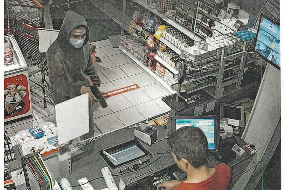 Einer der Räuber hat den Kassierer mit einer Pistole bedroht.
