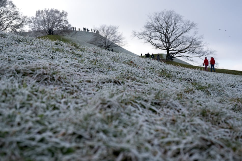 Ausflügler stehen am zweiten Weihnachtsfeiertag bei frostigen Temperaturen auf dem Olympiaberg in München.