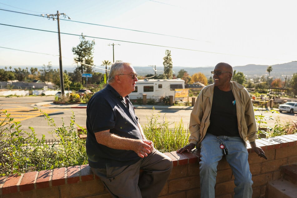 Neighbors Ted Koerner (l.) and Ellaird Bailey talk as construction finally begins to rebuild Bailey’s home across from Koerner’s house along East Loma Alta Drive in Altadena, California, on December 29, 2025