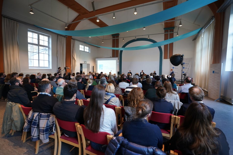 Teilnehmerinnen und Teilnehmer der öffentlichen Veranstaltung zum Wiederaufbau der Bornplatzsynagoge sitzen in der Talmud-Tora-Schule im Grindelviertel.