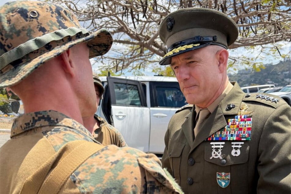 Commander of the US Southern Command Francis L. Donovan (r.) interacts with a US Marine assigned to stand watch at the US Embassy facilities in Caracas, Venezuela, on February 18, 2026.