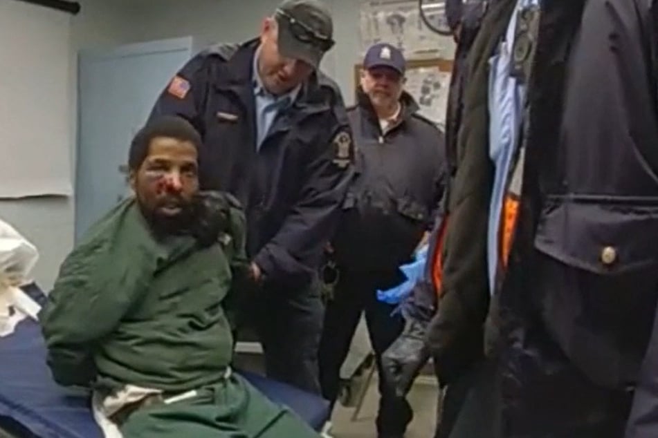 Footage, taken from body cameras worn by guards, shows Robert Brooks (l.) with a bloody face and being repeatedly beaten as he appears to be restrained on a hospital bed with at least six men around him.