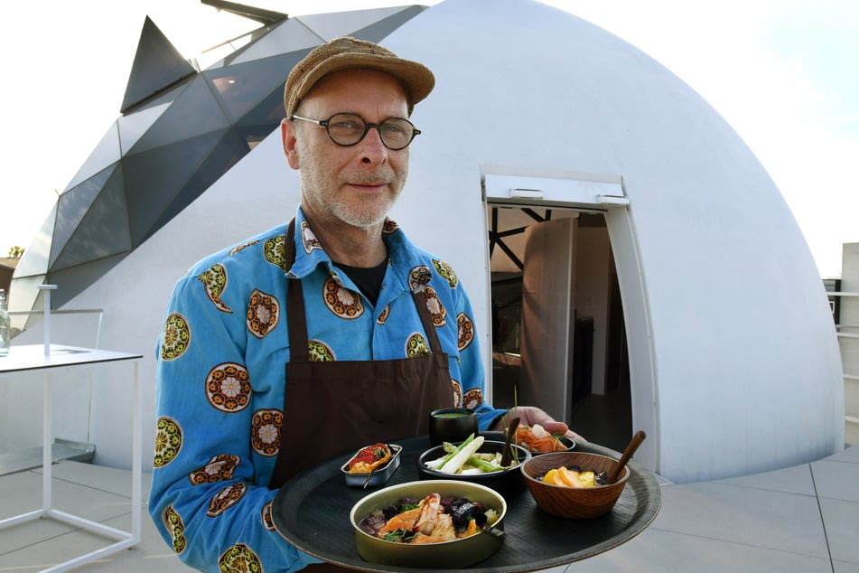 Der Koch Tibor Herzigkeit serviert das Essen in kleinen Schälchen auf der Terrasse der "Niemeyer Sphere".
