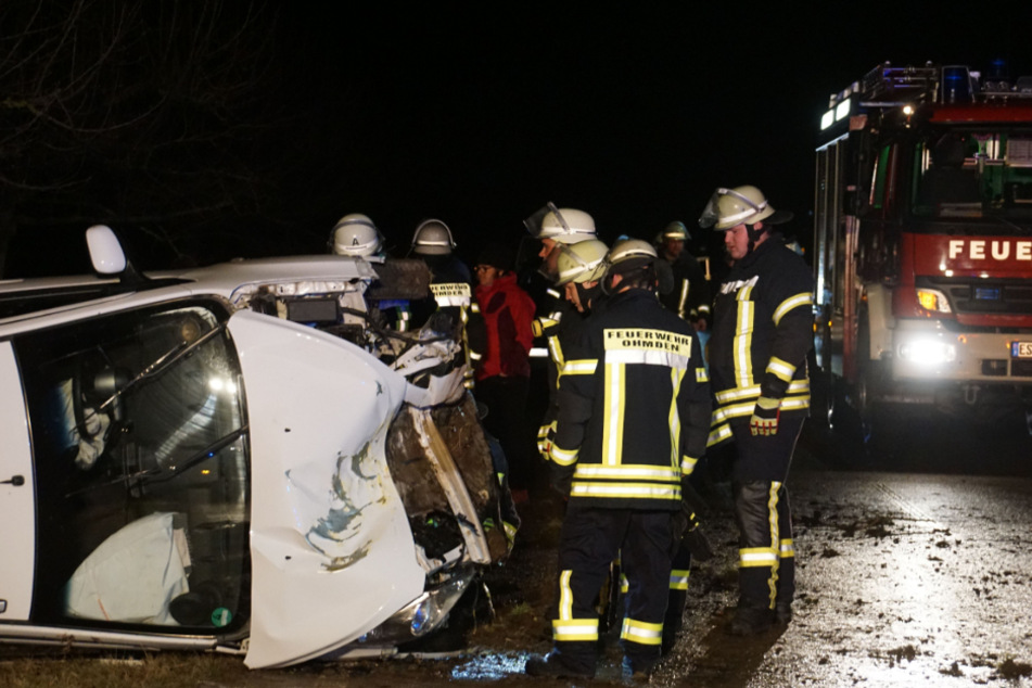 Feuerwehrmänner begutachten das am Unfall beteiligte Auto.