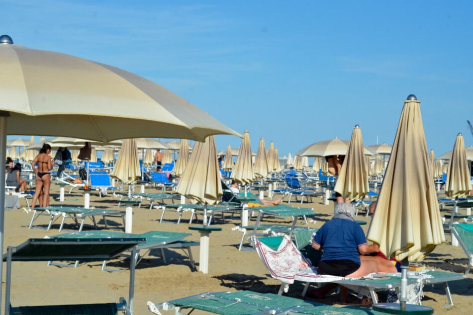 Strandbesucher sonnen sich auf den Liegen.