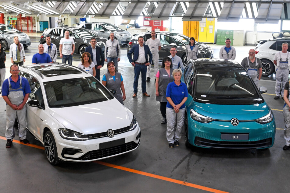 Mitarbeiter des Werkes von Volkswagen Sachsen stehen im Finish der Linie um einen VW Golf Variant und neben dem neuen ID.3. Als Nächstes wird nun auch der ID.4 in Zwickau gebaut.