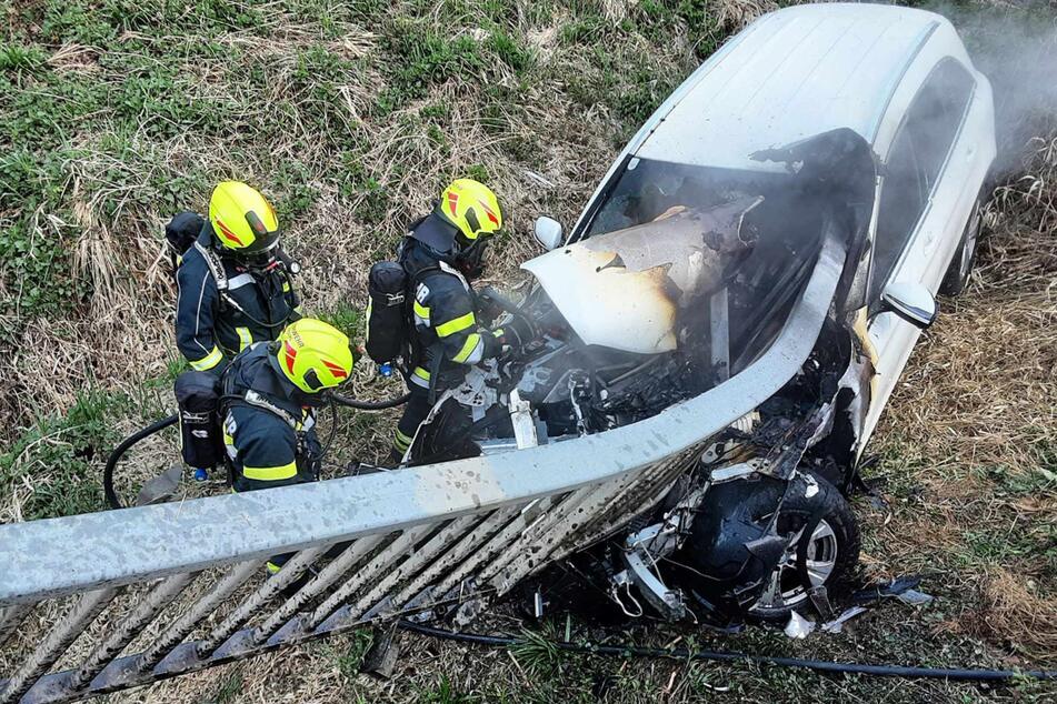 Kameraden der Freiwilligen Feuerwehr Preding löschen das brennende Unfallauto.