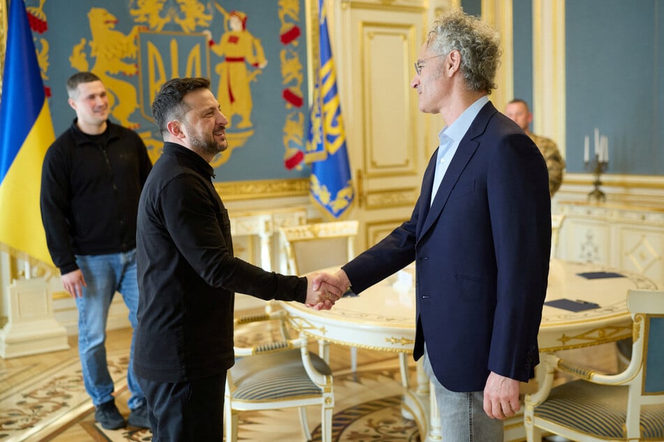 Ukraine's President Volodymyr Zelensky (c.) welcomes Palantir Technologies CEO Alex Karp (r.) while Ukrainian Defense Minister Mykhailo Fedorov smiles in the background, on May 12, 2026.