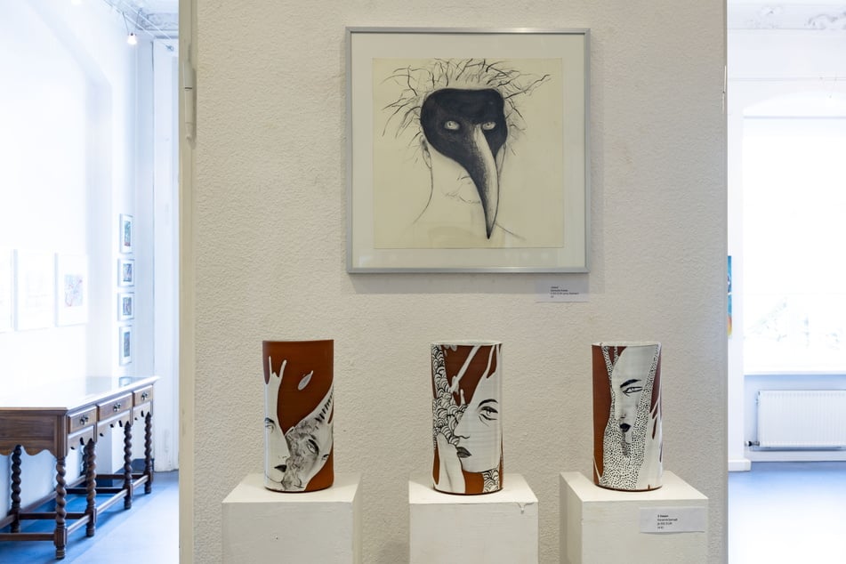 Blick in die Ausstellung: Unter einem Selbstporträt Hampels mit Pestmaske sind drei bemalte Keramik-Vasen platziert.