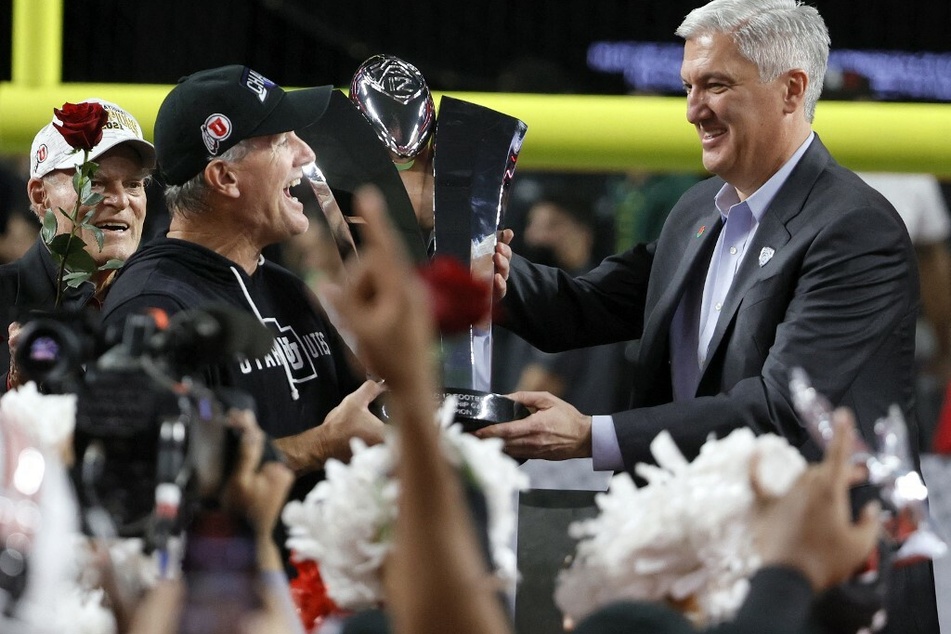 Head coach Kyle Whittingham (2nd from l.) of the Utah Utes accepts Pac-12 Conference Championship trophy from Pac-12 Commissioner George Kliavkoff.
