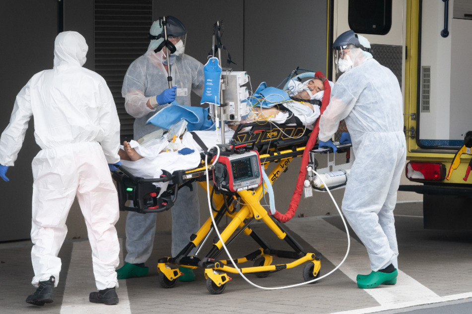 Wiederholt sich Geschichte? Notfallmediziner bringen einen Corona-Patienten aus Italien in Schutzkleidung auf die Intensivstation des Dresdner Uniklinikums.