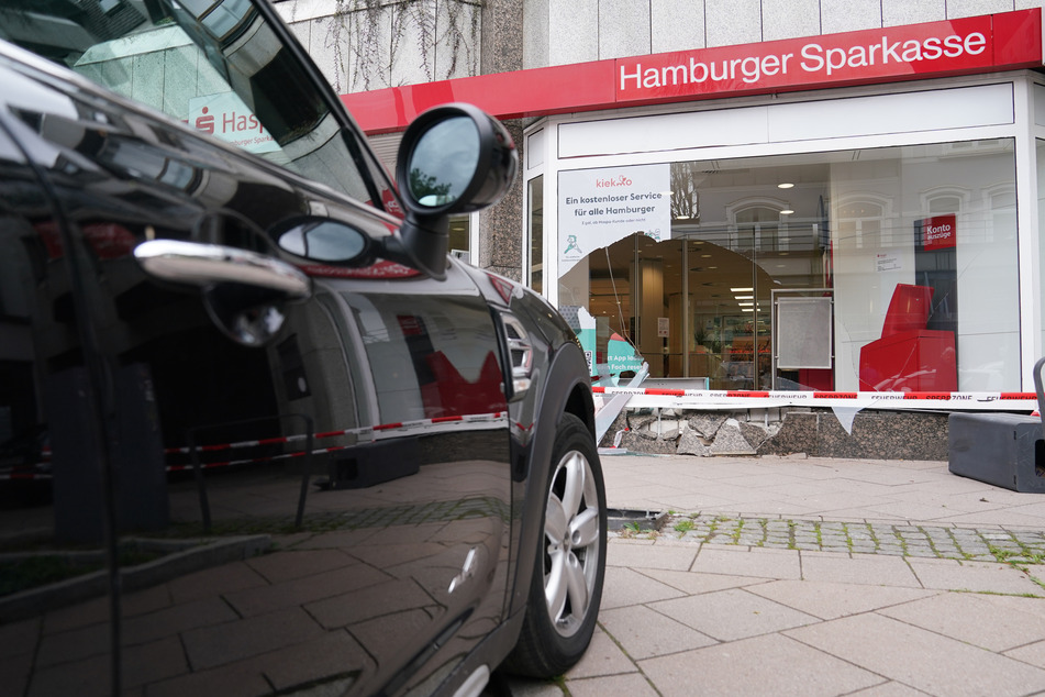 Das Unfallfahrzeug steht vor der zerstörten Schaufensterscheibe einer Haspa-Filiale.