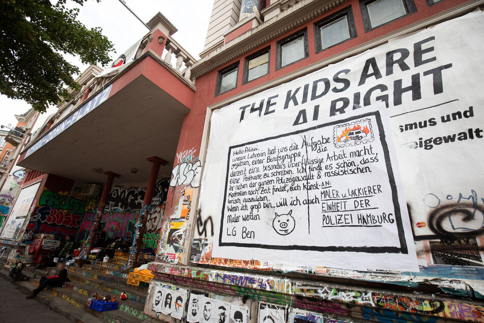 Ein Plakat mit einem kritischen Text klebt an einer Aussenwand des linksautonomen Kulturzentrums Rote Flora im Hamburger Schanzenviertel.