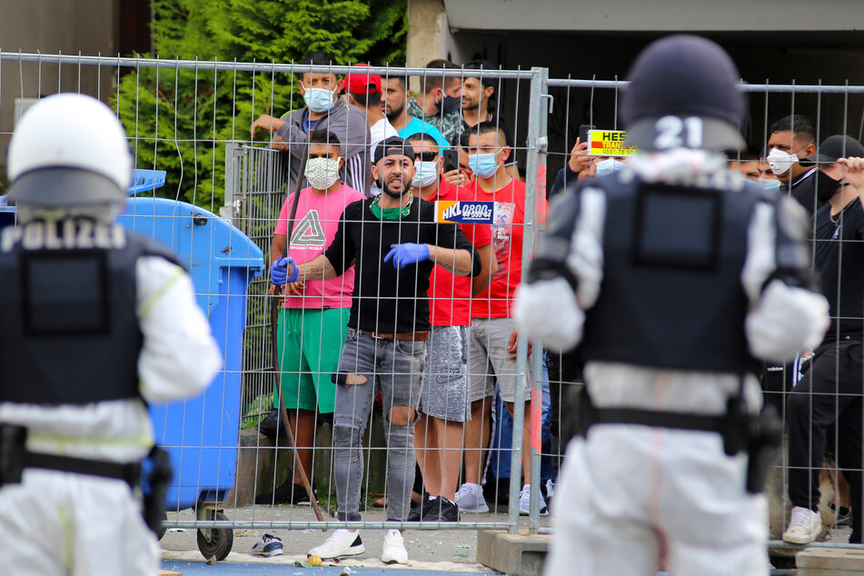 Niedersachsen, Göttingen: Auf Polizisten, die vor dem Wohnkomplex an der Groner Landstraße stehen, der komplett unter Quarantäne steht, sehen sich einer Gruppe junger Männer gegenüber, die sich hinter einem Zaun versammelt hat. (Archivbild)