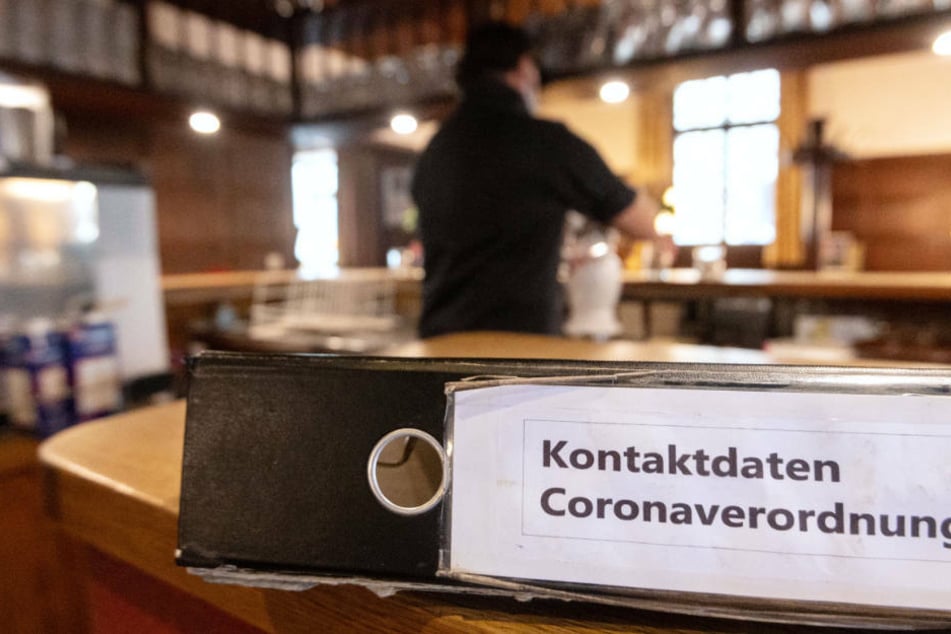 Ein Ordner mit der Aufschrift "Kontaktdaten Coronaverordnung" liegt in einer Gaststätte auf der Theke. (Symbolbild)