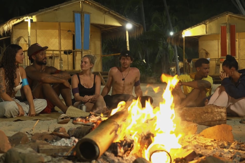 Die restlichen Teilnehmer der Survival-Show rekapitulieren die vergangene Zeit am Lagerfeuer.