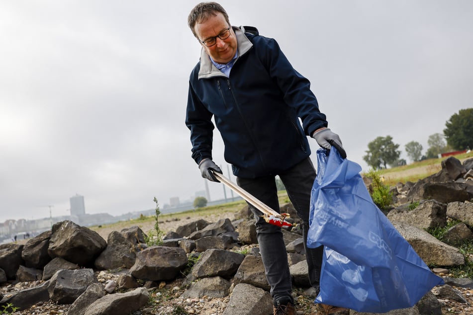 In ungewohnter Montur und mit einem blauen Müllsack bewaffnet machte sich auch NRW-Umweltminister Oliver Krischer (57, Grüne) auf die Suche nach Müll und Unrat am Rheinufer.