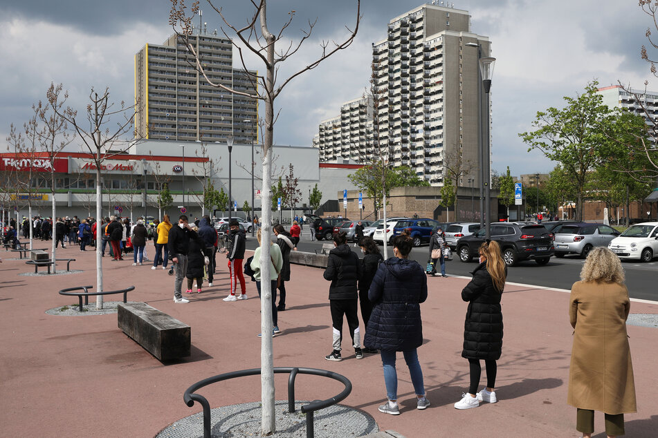 Menschen stehen für eine Impfung mit dem Impfstoff von Moderna an. Die Stadt Köln hat im Stadtteil Chorweiler mit Impfungen in sozialen Brennpunkten begonnen.