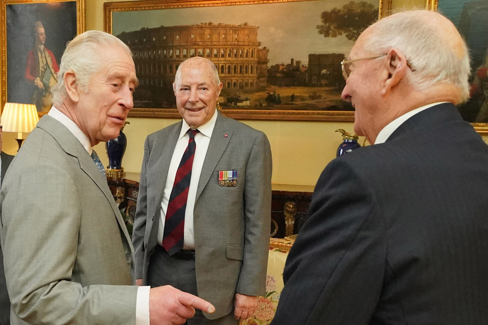 King Charles (l.) met with veterans of the Korean War on Tuesday, a day after false claims of his death spread online.