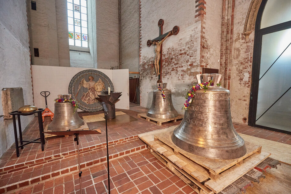 Die Kleinste (l., 754 kg) der drei Glocken wurde nach einer Andacht in den Turm von St. Marien hochgezogen.