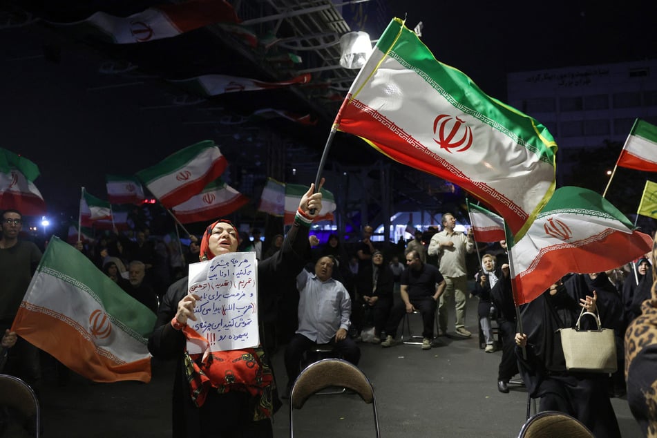 People wave Iran's national flag during an anti-US and Israel protest in Tehran on May 29, 2026.