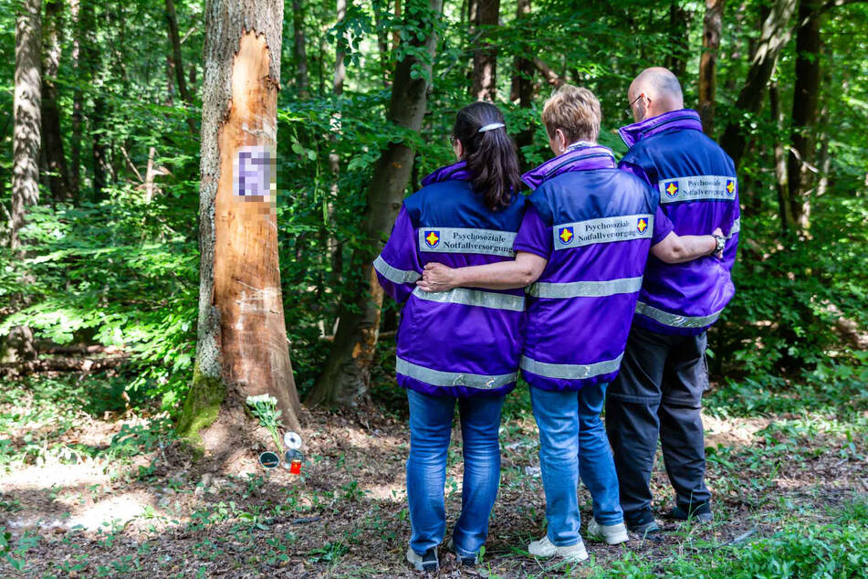 Drei Notfallseelsorger stehen vor einem Baum nahe des Unfallortes bei Hofheim. Hier starben bei einem Crash drei junge Männer im Alter von 17 bis 18 Jahren.