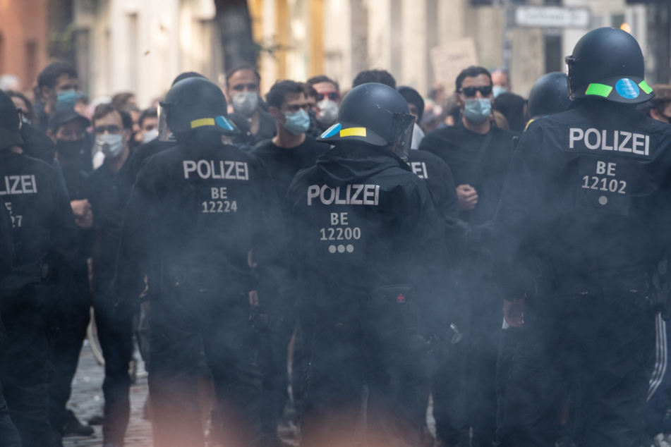 Polizeibeamte gehen in Rauch gehüllt in der Weisestraße.