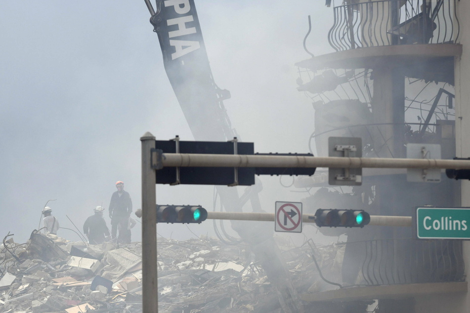 A fire deep inside the collapsed Champlain Towers hampered rescue efforts Saturday morning, creating a gray haze and filling the air with the smell of smoke.