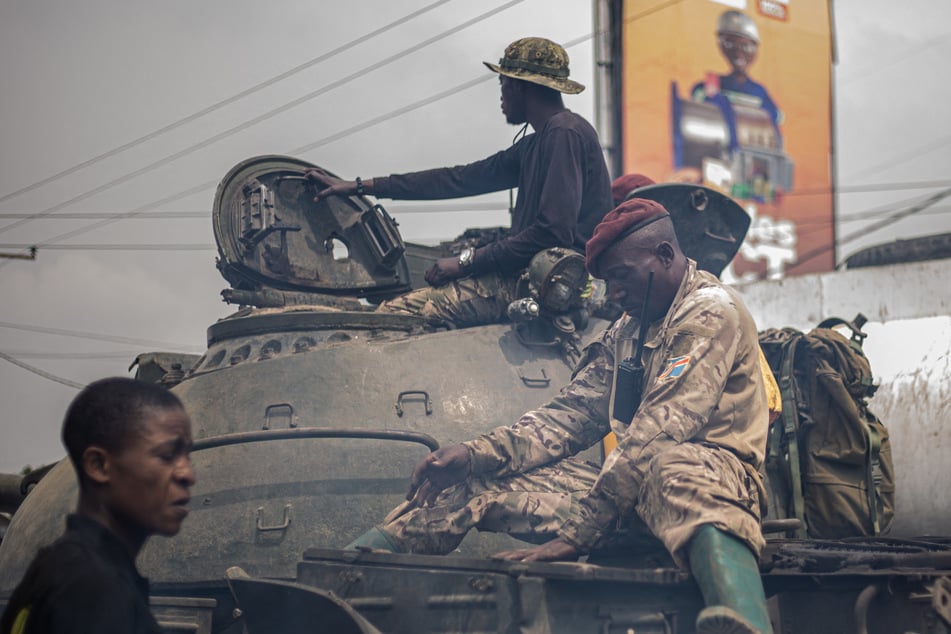 Soldiers of the Armed forces of the Democratic republic of Congo (FARDC) ride on top of a tank as they leave the city of Goma, on January 23, 2025 towards Sake.