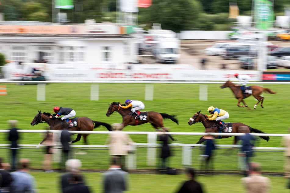 Jockeys galoppieren auf ihren Pferden über die Rennbahn beim 151. Galopp-Derby.