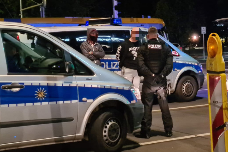 Beamte bewachen einen der Männer, die die Dealerin begleitet hatten - und bei dem Einsatz ebenfalls festgenommen wurden.
