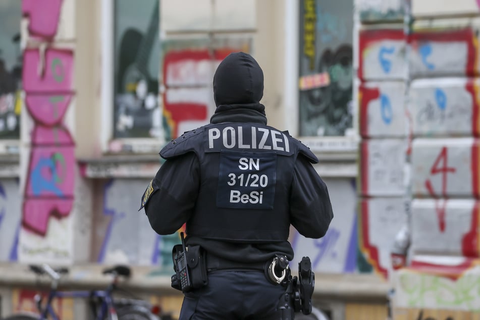 Eine Polizeibeamtin steht während Durchsuchungen im Leipziger Stadtteil Connewitz.