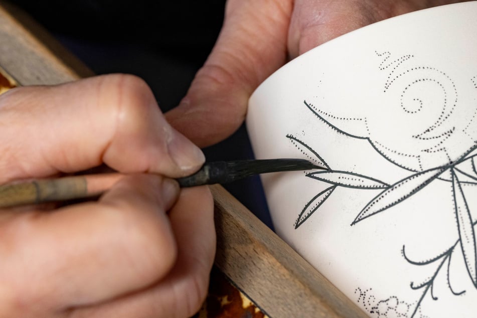 Per Hand wird das Zwiebelmuster vor dem zweiten Brand auf das Porzellan gemalt.
