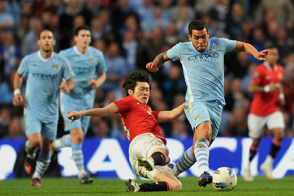 Carlos Tevez (r.) ist einer von lediglich 14 Fußballern, die sowohl für Man City als auch für Man United gespielt haben. (Archivfoto)