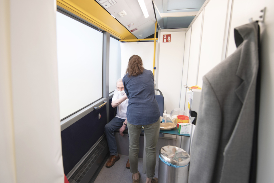 Ein Mann wird in einem Bus geimpft. (Symbolbild)