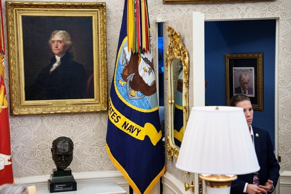 A copy of President Donald Trump's mugshot on the front of the New York Post is framed just outside the Oval Office at the White House.