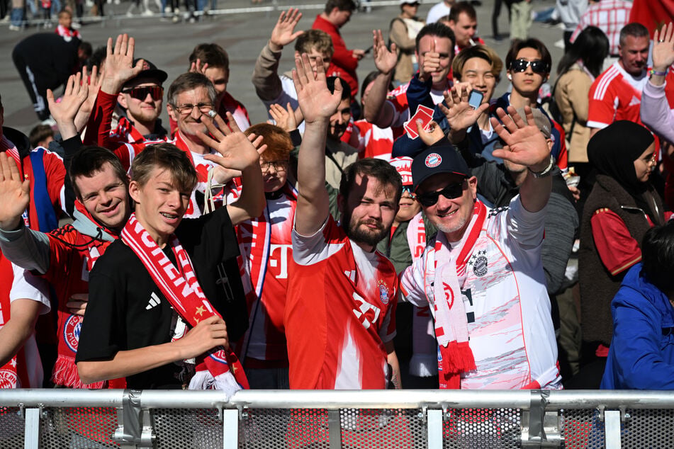Einen Platz in der ersten Reihe: Diese Bayern-Fans warten am Marienplatz darauf, dass die Mannschaft auf den Balkon des Rathauses tritt.