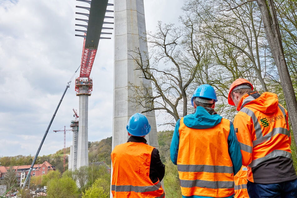 Bauarbeiter und Ingenieure überwachten, wie sich der Stahlüberbau mit dem roten Vorbauschnabel in einer Geschwindigkeit von etwa 24 Metern pro Stunde vom Sonnenstein in Richtung Kohlberg bewegte.