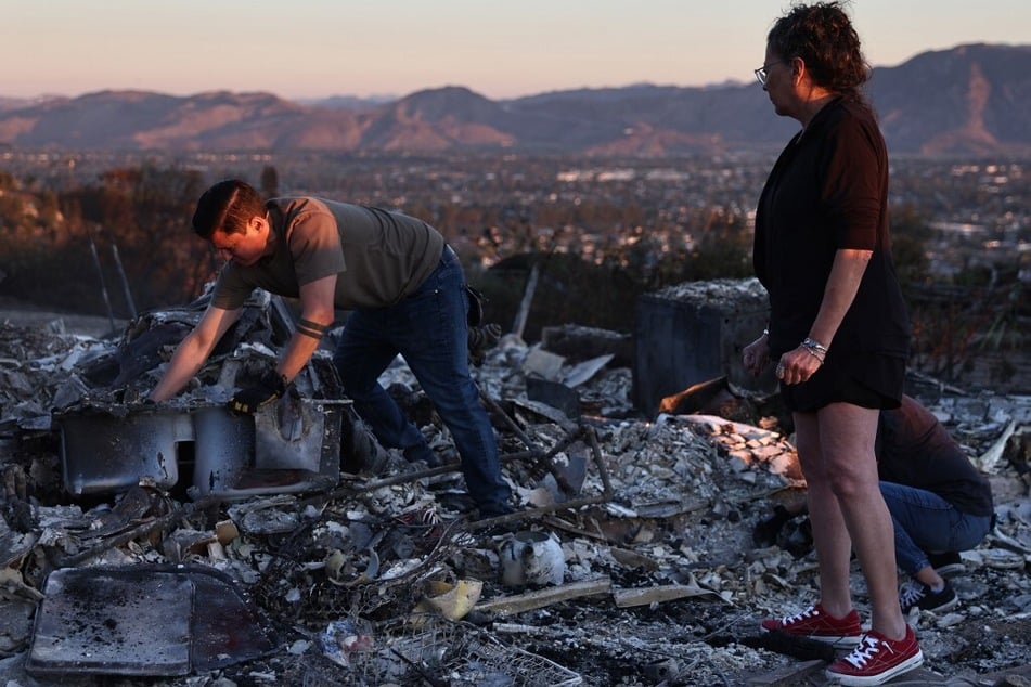 Louie Gonzalez (l.) helps his mother Kathy (r.) search through the rubble of her home, which was destroyed in the Mountain Fire on November 8, 2024, in Camarillo, California.