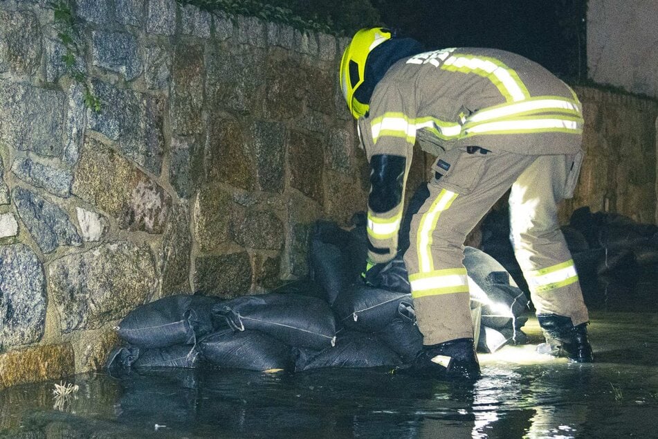 Kameraden der Görlitzer Feuerwehr stapelten Sandsäcke, um das Wasser an der Mauer zu stoppen.