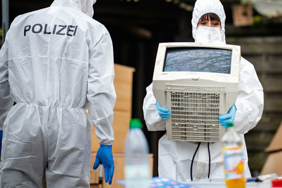Eine Polizeibeamtin der Spurensicherung trägt einen sichergestellten Monitor. (Symbolbild)