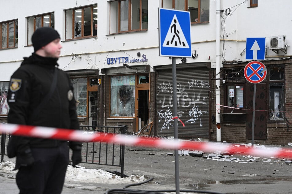 A Ukrainian police officer secures an area at the site of an explosion that rocked a shop in Lviv on February 22, 2026.