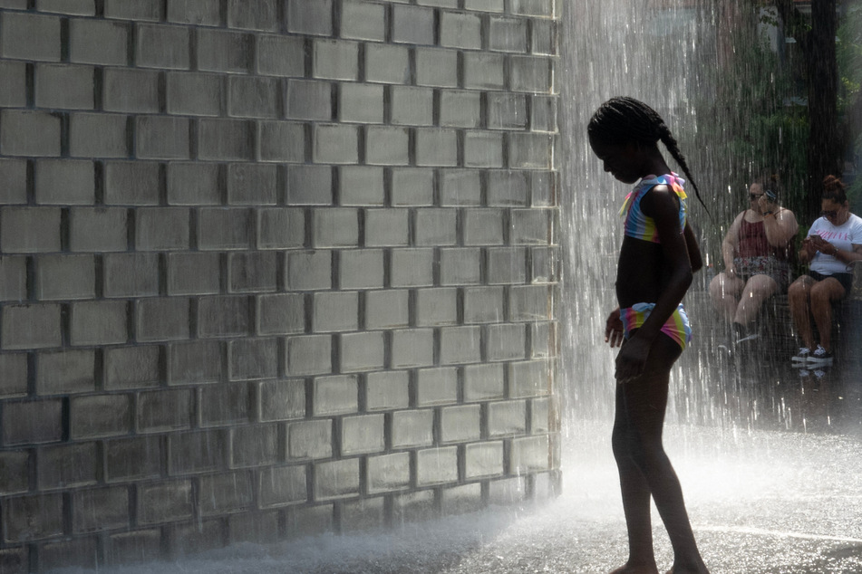 A child cools off at Crown Fountain in Millennium Park as temperatures reached a record high of 97 degrees Fahrenheit on Monday.