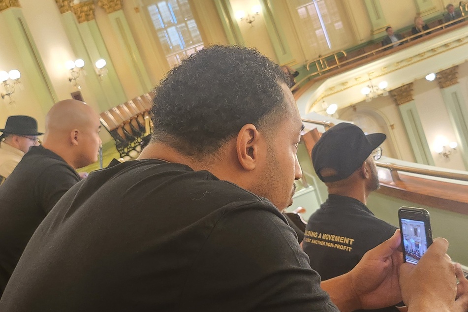 Racial justice advocates watch from the gallery as members of the California Assembly vote on ACA 8.