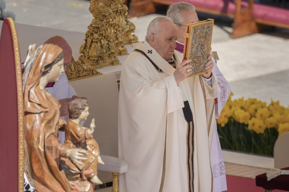 Papst Franziskus (85) hält das Evangelienbuch während der katholischen Ostermesse auf dem Petersplatz im Vatikan hoch.
