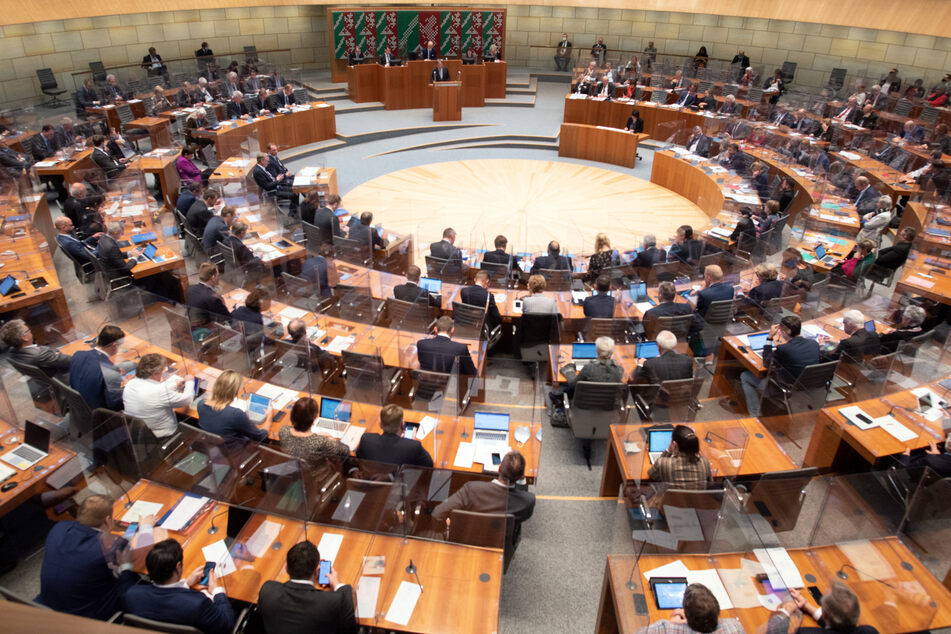 Armin Laschet (CDU, hinten M), Ministerpräsident von Nordrhein-Westfalen, spricht im Landtag. Wegen der Corona-Pandemie kommt der nordrhein-westfälische Landtag zu einer Sondersitzung zusammen.