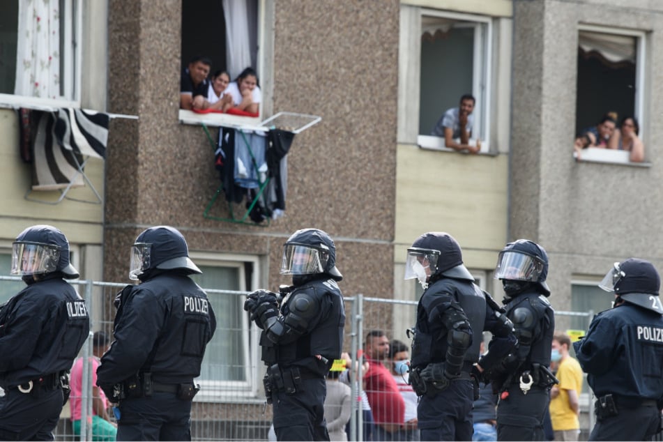 Polizisten stehen vor einem unter Quarantäne gestellten Wohngebäude in der Göttinger Innenstadt.