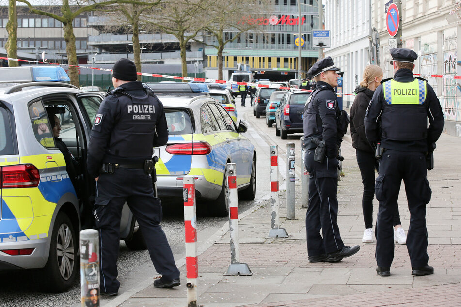 Polizisten stehen an einer gesperrten Straßen in Hamburg-Ottensen. Dort wurden in einem Mehrfamilienhaus am Dienstagmorgen zwei Tote gefunden.