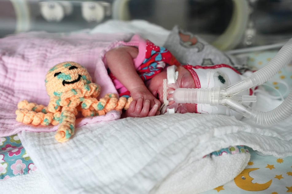 Kämpferin Emma kam mehr als 14 Wochen zu früh zur Welt. Neben den wertvollen Kuscheleinheiten mit ihren Eltern hat sie im Wärmebettchen auch ihren gehäkelten Begleiter an der Seite.