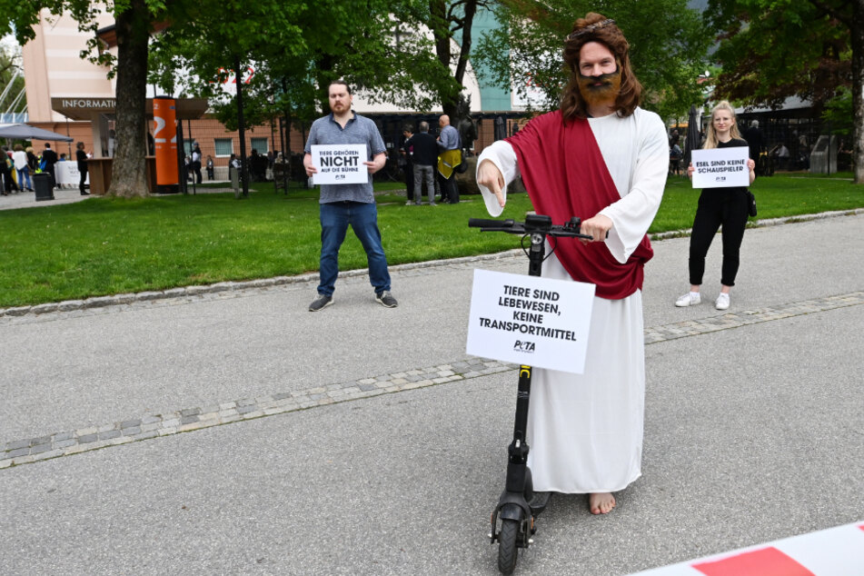 Ein als Jesus verkleideter Aktivist der Tierrechtsorganisation PETA protestiert auf einem Elektroroller gegen den Einsatz von Tieren auf der Bühne.